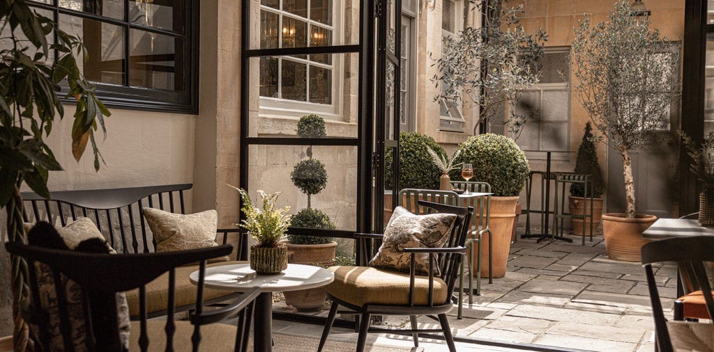 Elegant boutique hotel facade with stone exterior, featuring warm lighting, modern design, and charming urban courtyard in historic Bath, UK setting