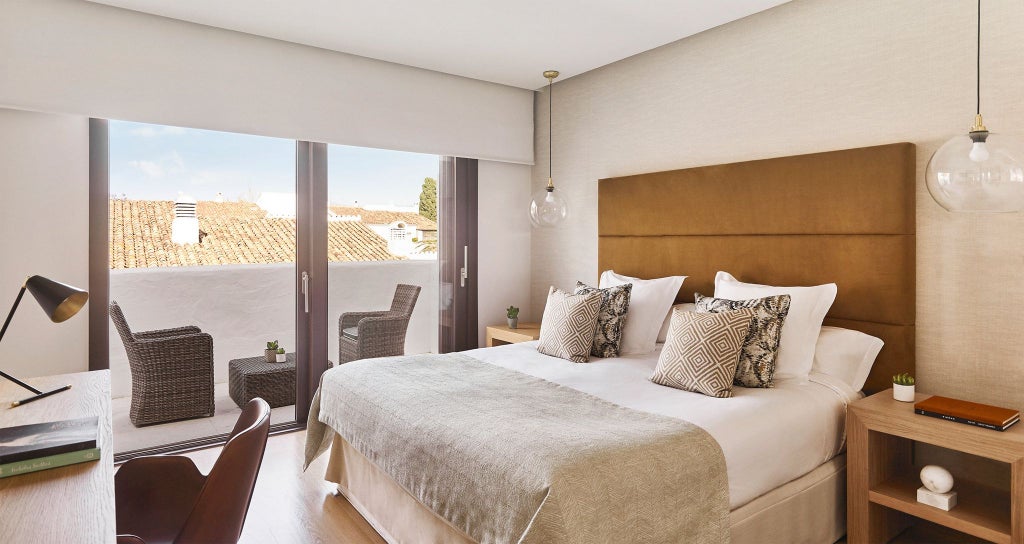 Spacious Nobu Hotel Marbella Four Bedroom Suite with modern white decor, plush furnishings, and panoramic views of Mediterranean landscape through floor-to-ceiling windows