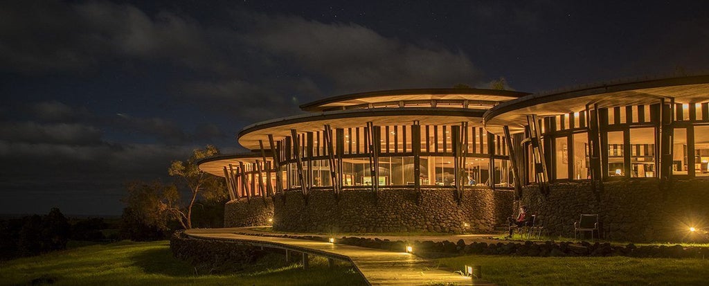 Luxurious eco-lodge nestled on Easter Island, with minimalist architecture blending seamlessly into dramatic volcanic landscape and Pacific Ocean coastline.