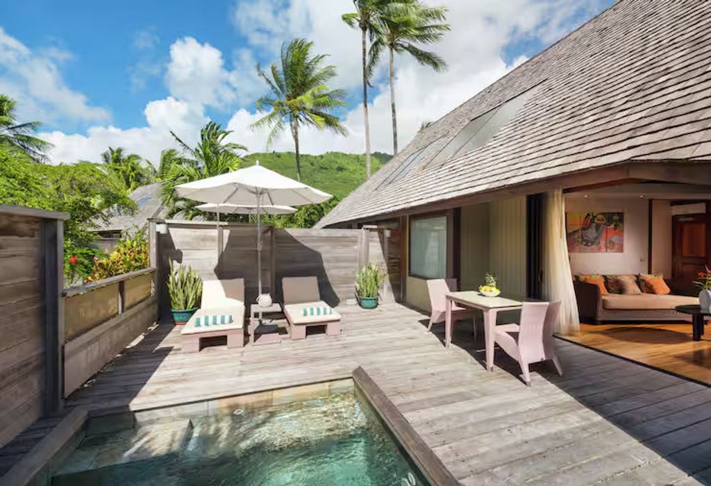 Luxurious garden bungalow with private plunge pool, thatched roof, wooden deck, and tropical landscaping at Hilton Moorea resort