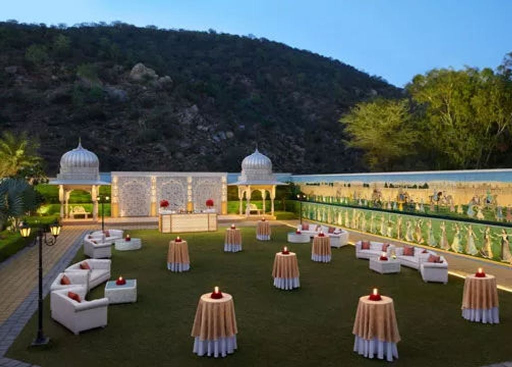 Majestic Leela Palace hotel in Jaipur with ornate Rajasthani architecture, grand dome, and pristine landscaped gardens at sunset