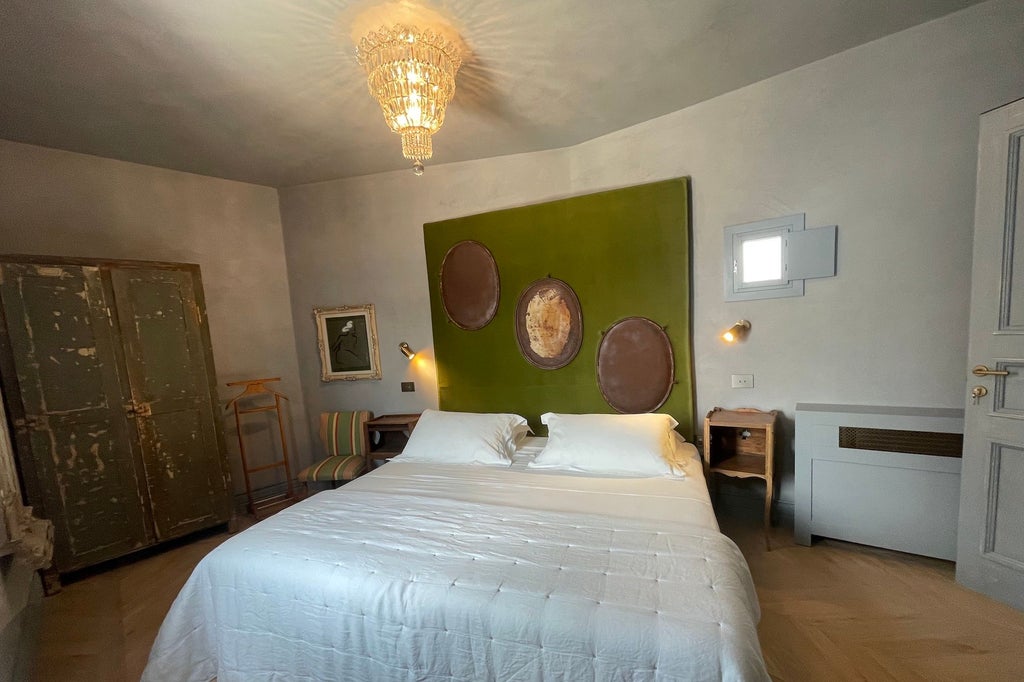 Opulent Deluxe Suite in an Italian boutique hotel with elegant white furnishings, plush bedding, and soft natural lighting from large windows