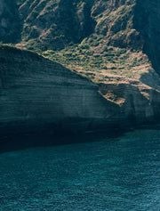 Elegant Mediterranean coastal hotel with white-washed architecture, panoramic sea views, and lush terrace overlooking scenic Aeolian Islands landscape