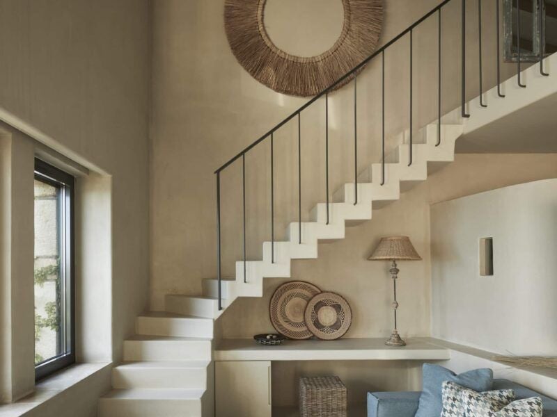 Minimalist raw wood mezzanine suite with white linens, large windows overlooking Kefalonian landscape, modern luxury retreat with elegant design and natural light