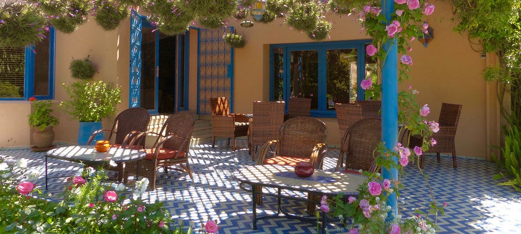 Elegant Moroccan villa nestled among orange groves featuring white-washed walls, terracotta roof tiles, and lush Mediterranean gardens