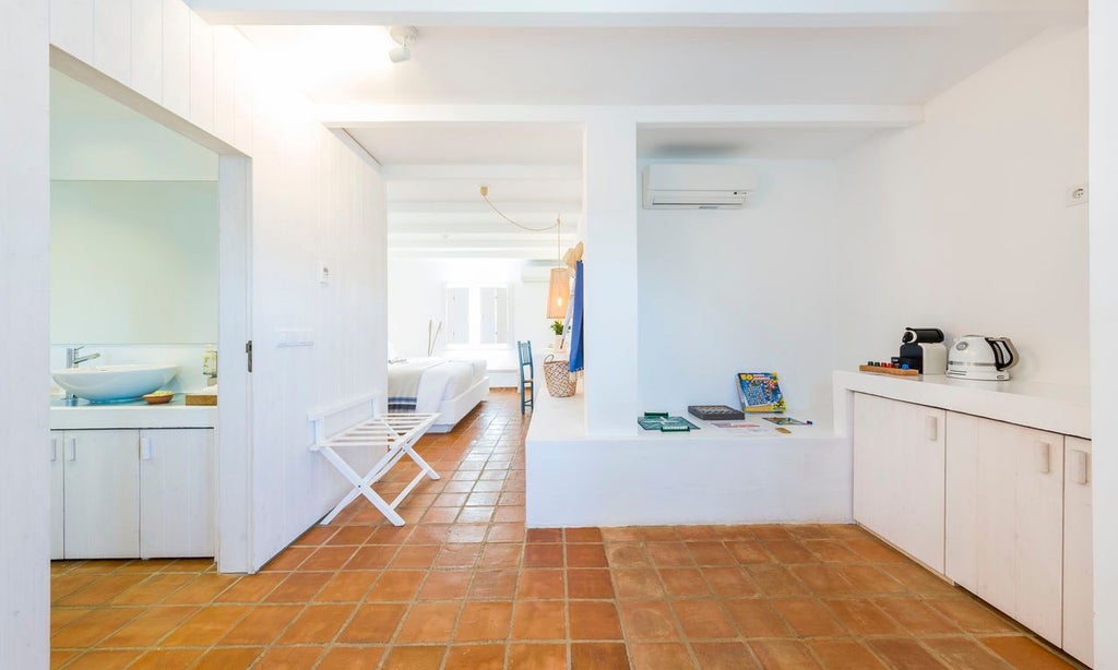 Elegant whitewashed Portuguese villa bedroom with minimalist design, soft neutral tones, wooden furnishings, and large windows overlooking serene landscape