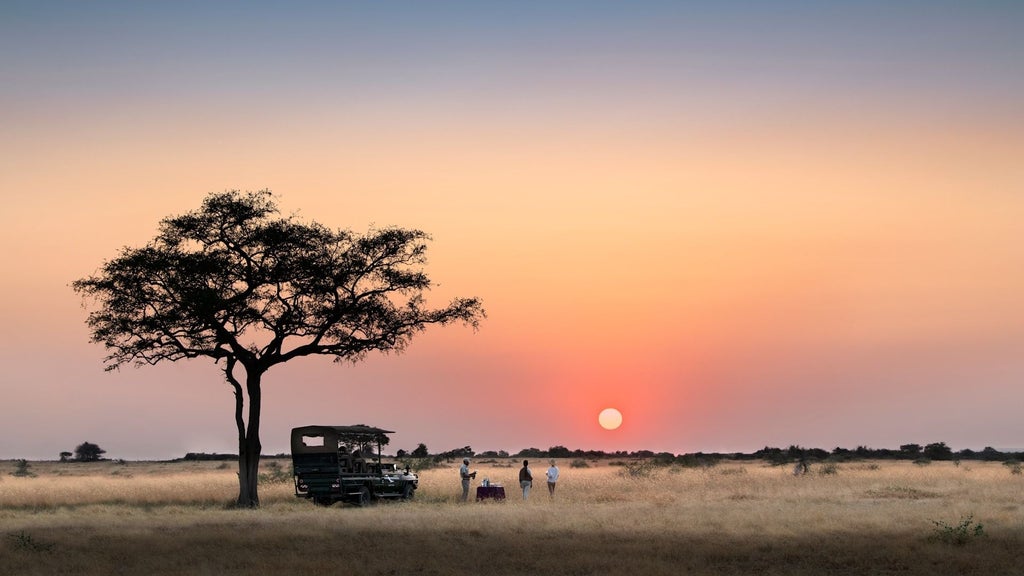 Luxurious safari lodge overlooking Serengeti plains, featuring thatched-roof pavilion with modern furniture and infinity pool at sunset