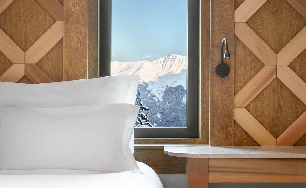 Five-star alpine hotel with wooden balconies nestled against snowy slopes, featuring traditional French architecture and mountain views