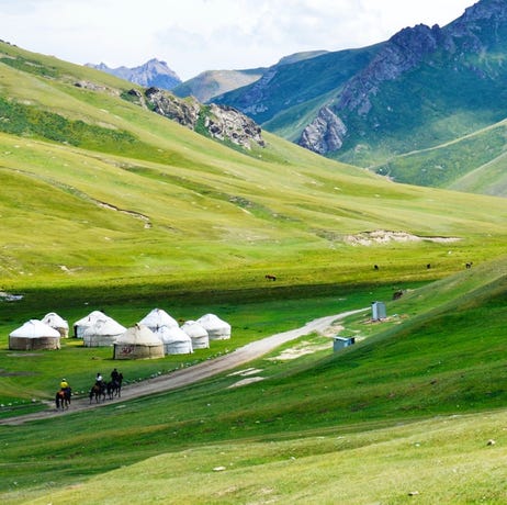 Yurts set up for the night in a lush green valley