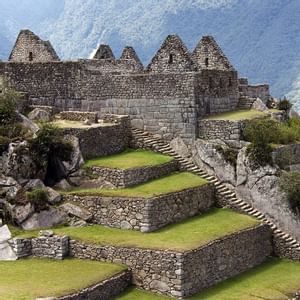 Five-star SUMAQ hotel exterior in Machu Picchu town, featuring modern stone and glass architecture nestled against lush mountain backdrop