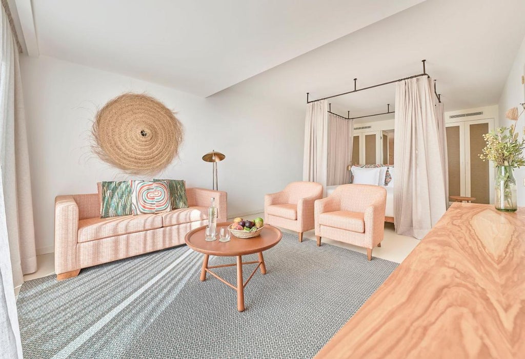 Traditional Portuguese villa-style hotel with white walls and terracotta roof overlooking turquoise ocean, framed by manicured gardens