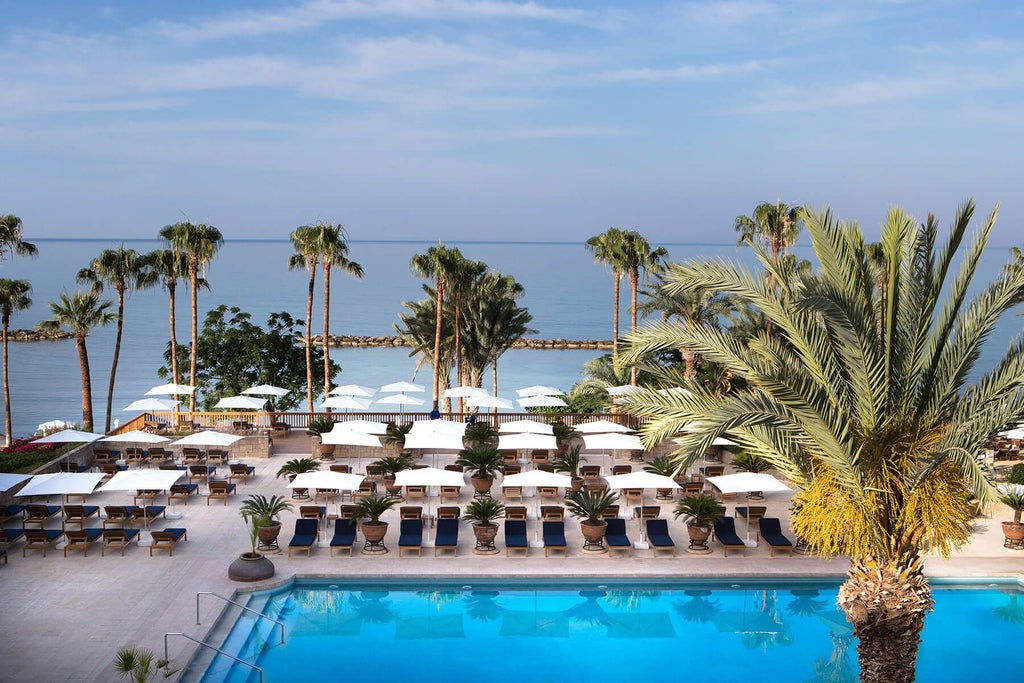 Luxurious seaside resort with pristine white architecture, azure pool, and Mediterranean backdrop at Scenset Hotel in Cyprus