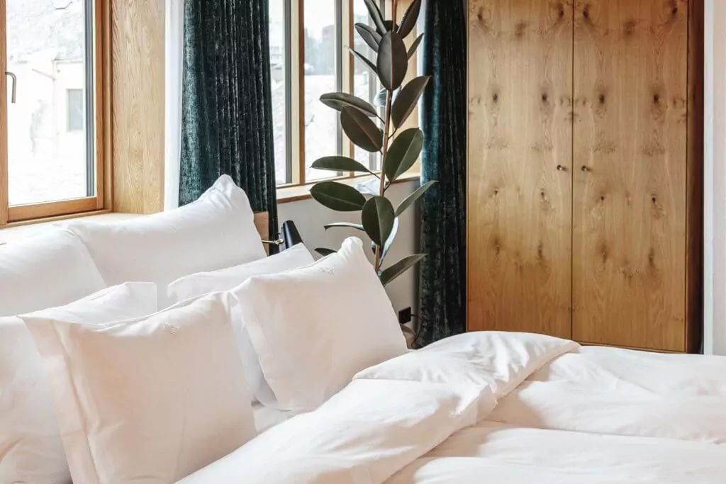 Luxurious superior suite at Scenset Hotel with modern Nordic design, wooden floors, floor-to-ceiling windows overlooking coastal Norwegian landscape