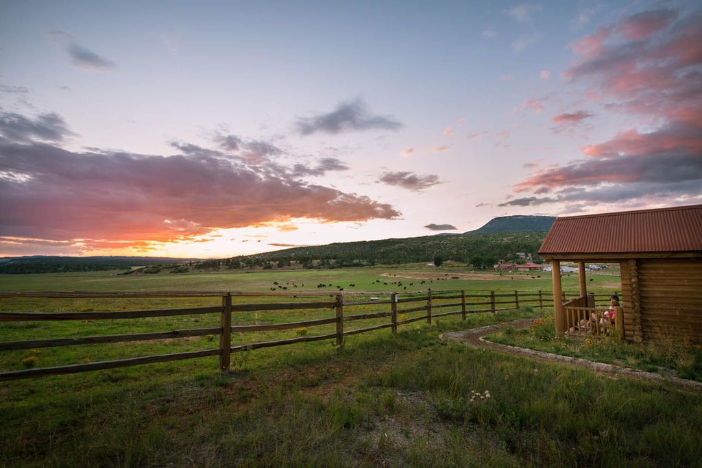 Rustic log cabin resort nestled against rugged mountain backdrop, showcasing elegant Western-style architecture with natural wooden exteriors and expansive landscape views