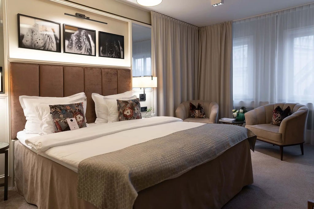 Luxurious Swedish hotel room with soft grey textiles, minimalist wooden furniture, crisp white linens, and modern pendant lighting in neutral tones