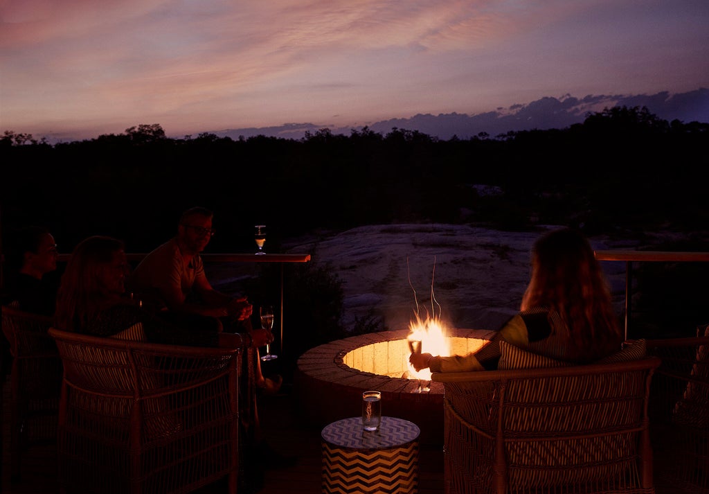 Elevated safari tent suite with private deck overlooking African bush, featuring teak furniture and canvas walls at Londolozi Founders Camp