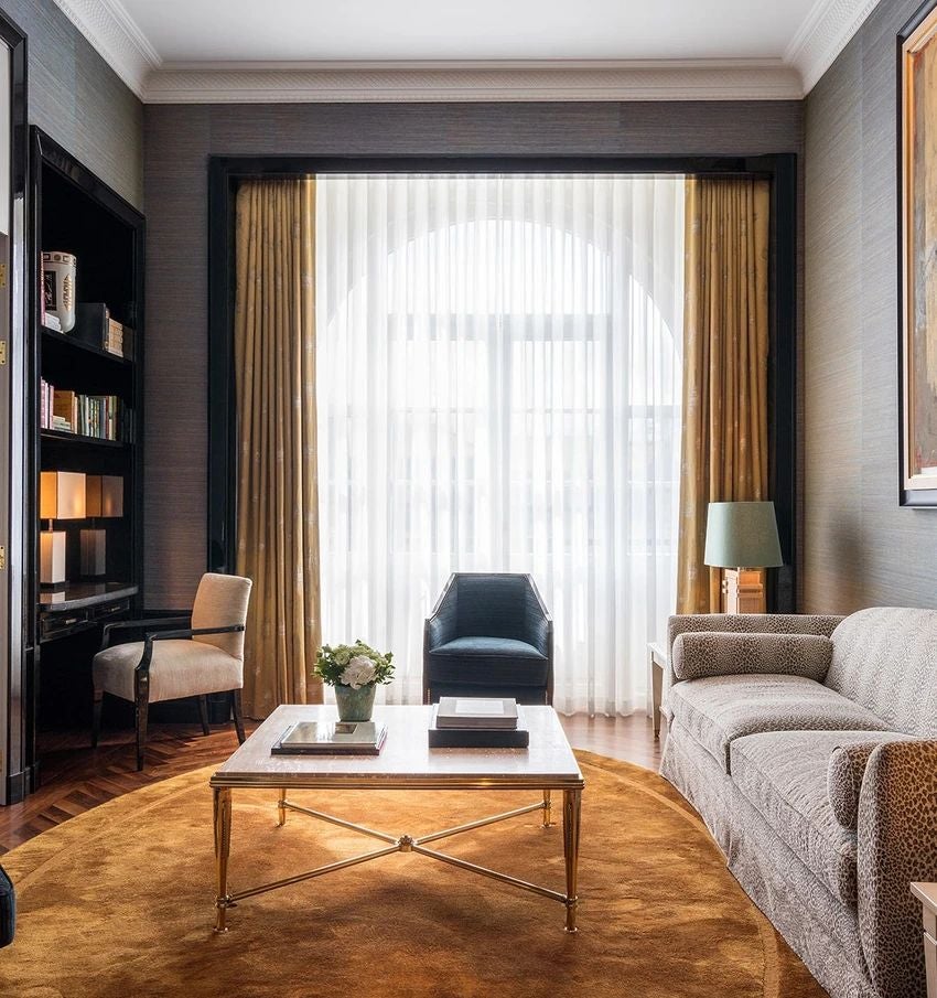 Elegant art deco suite with ornate chandelier, plush king bed, marble bathroom, and panoramic cityscape view at historic luxury hotel in Porto, Portugal