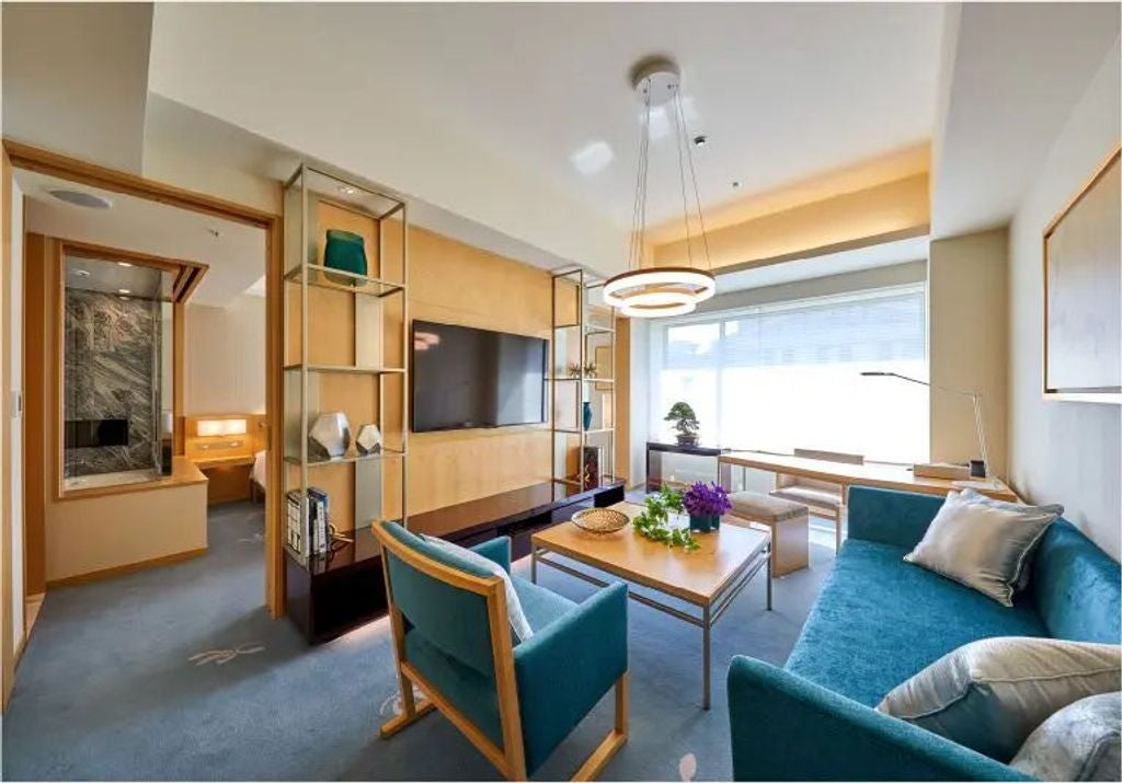 Luxurious winter-themed suite with tatami seating area, traditional Japanese sliding doors, and snow-covered mountain views through windows