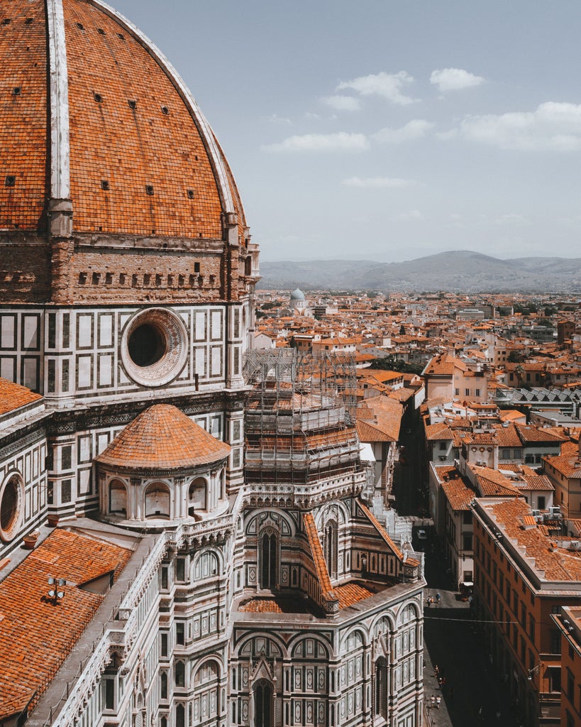 Elegant cobblestone street in Florence with historic Renaissance architecture, warm terracotta buildings, and sunlit stone facades