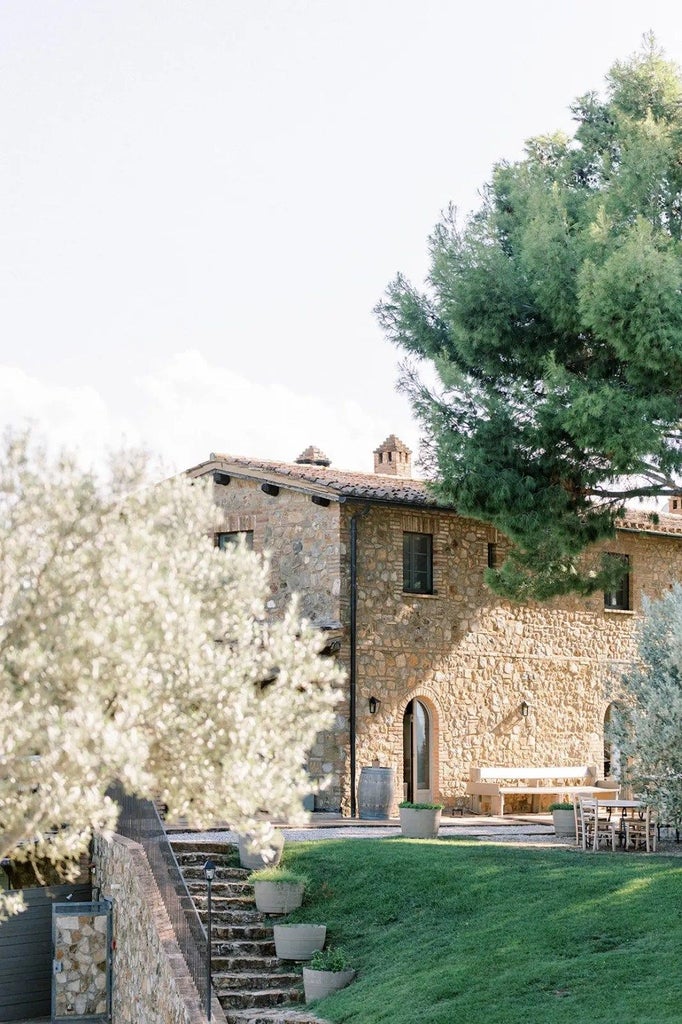 Luxurious Tuscan wine resort nestled among rolling vineyards, with elegant stone architecture and sweeping countryside views at sunset