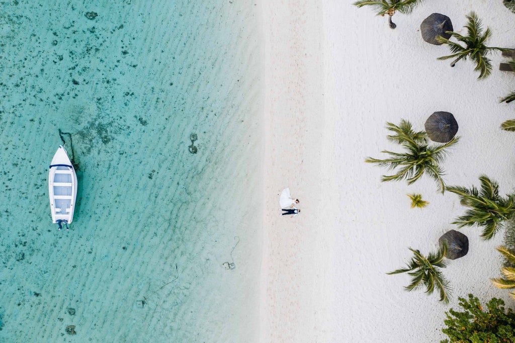 Vibrant sunset over Mauritius coastline with crystal-clear lagoon, palm trees swaying, and luxurious beachfront villas in the distance