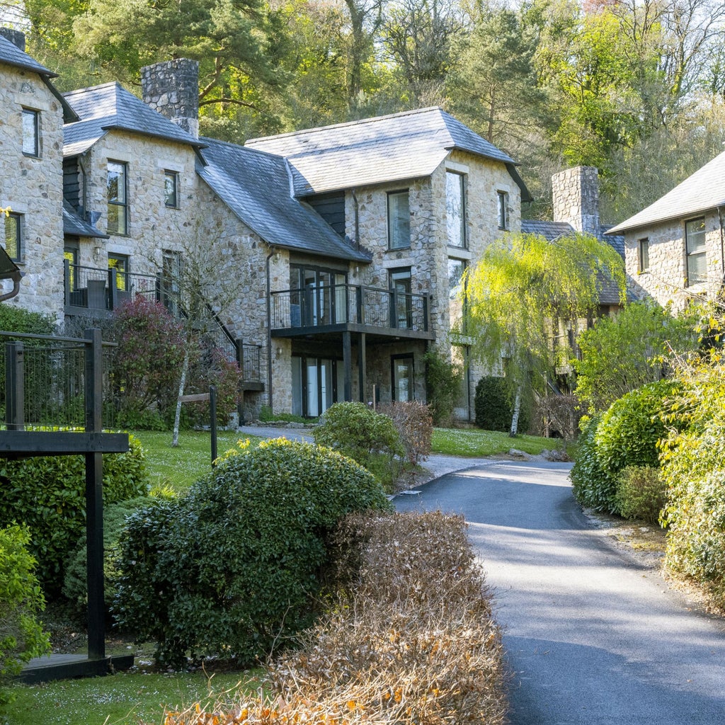 Luxury manor hotel nestled in lush Dartmoor scenery, featuring grand stone architecture, manicured gardens, and elegant exterior with classic British countryside charm