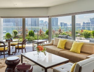 Opulent terrace suite with panoramic Barcelona views, featuring elegant period furniture, marble fireplace, and luxurious French doors