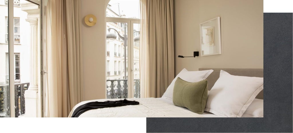 Luxurious connecting hotel suite at La Résidence Nell, featuring elegant French design with plush bedding, soft neutral tones, and modern minimalist decor