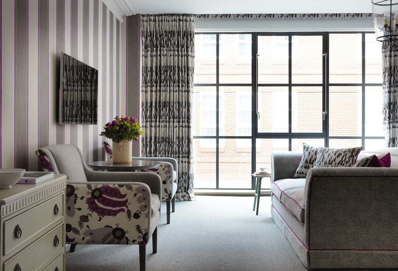 Elegant deluxe room at Ham Yard Hotel with contemporary design, plush king bed, stylish artwork, and warm neutral color palette showcasing British boutique luxury.