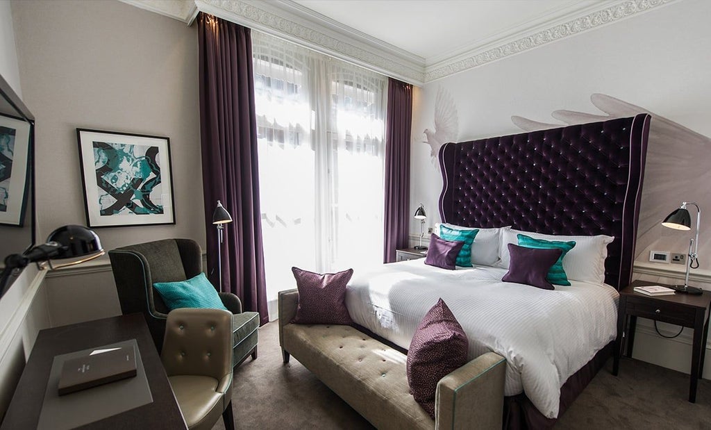 Elegant deluxe hotel room with plush white bedding, contemporary design, and sophisticated decor at a luxury boutique accommodation in United Kingdom.