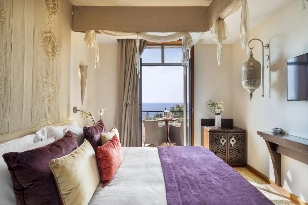 Elegant deluxe hotel room with expansive Mediterranean sea view, plush white bedding, modern decor, and soft natural lighting at Tiara coastal resort