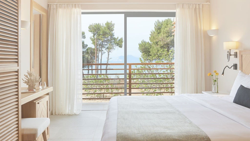 Luxurious sunset suite with minimalist design, panoramic sea view, private balcony, and modern white decor overlooking the Aegean coastline of Skiathos island