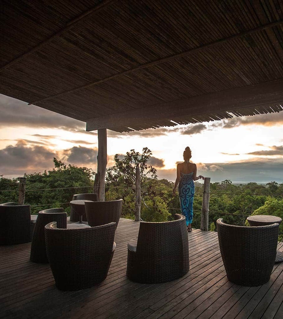 Spacious canvas-walled safari tent with wooden floors, cozy bed, and panoramic views of lush Ecuadorian landscape at Galapagos Safari Camp