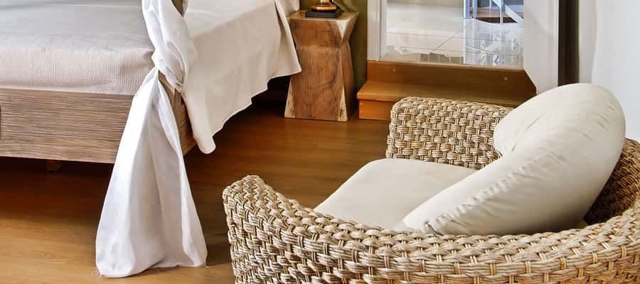 Luxurious white-washed villa bedroom with minimalist design, panoramic sea view, wooden floors, and elegant Mediterranean coastal decor in Greece