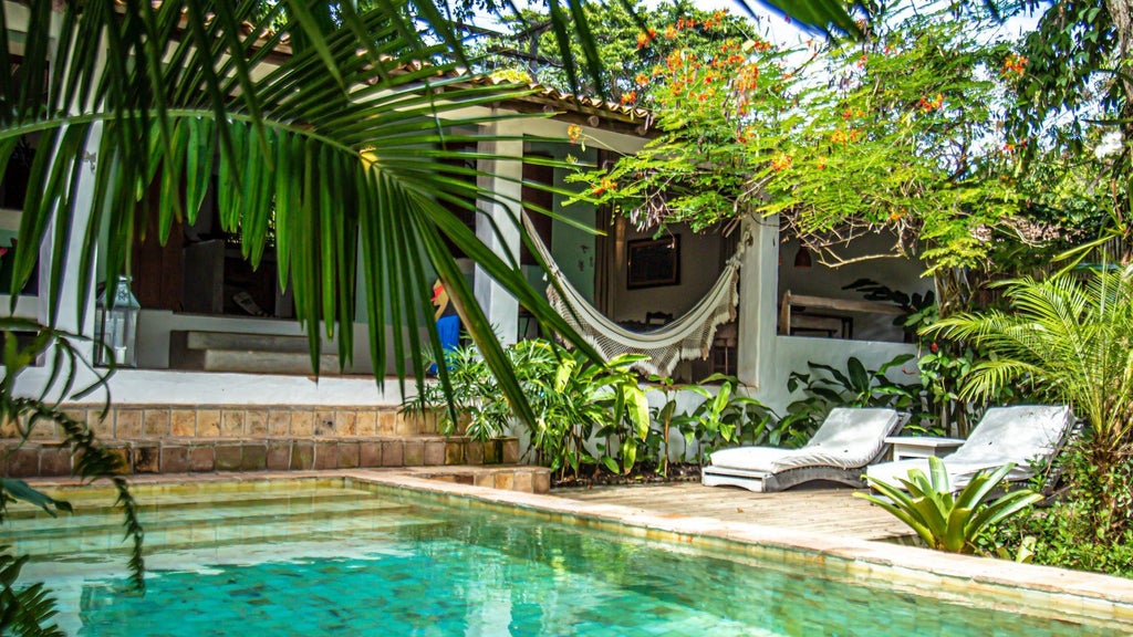 Luxurious Brazilian beachside suite with warm wooden interiors, rustic canopy bed, and expansive ocean view at UXUA Casa Hotel and Spa in Trancoso