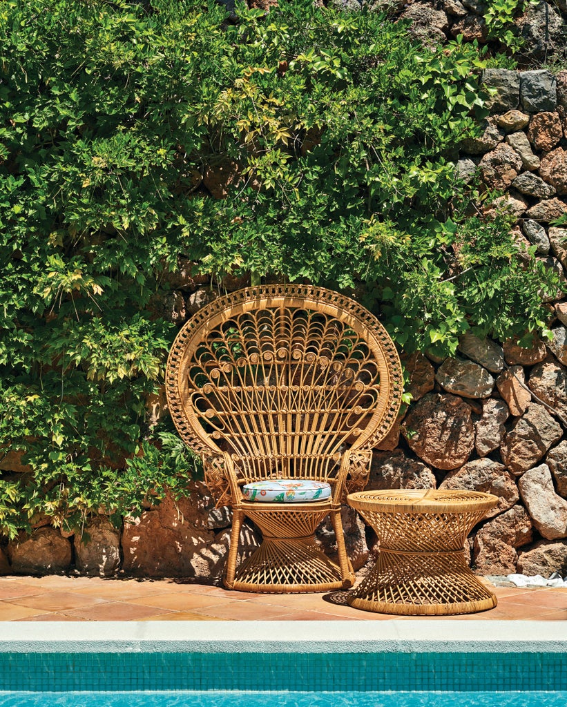 Luxurious Mediterranean hotel nestled in Mallorca's mountains with stone facade, terracotta roof, and lush garden terraces