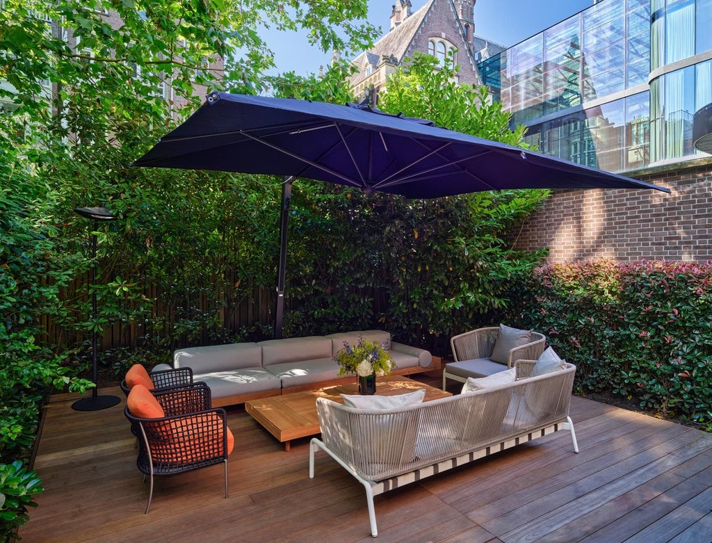 Luxurious garden-view suite with modern Dutch design, blending refined minimalism and natural light in elegant Conservatorium Hotel accommodations