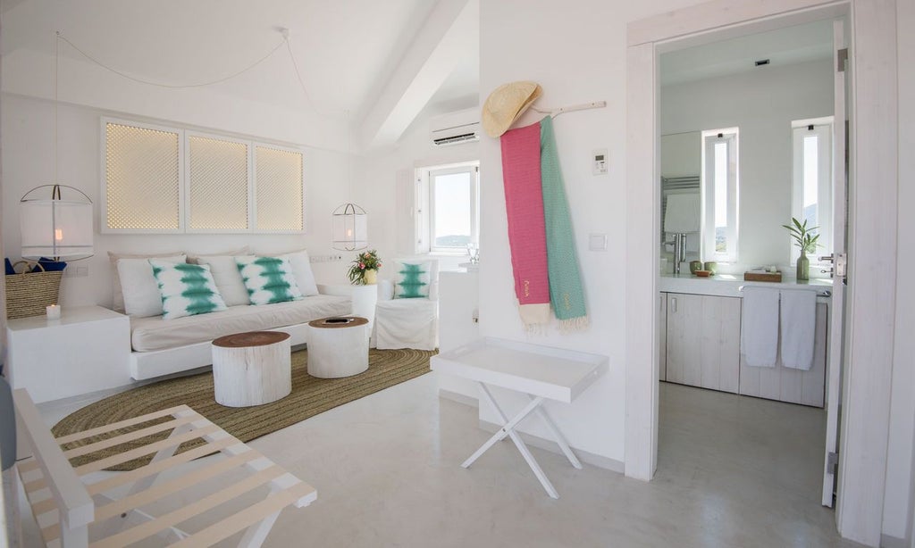 Elegant white-walled Portuguese hotel room with minimalist design, wooden floors, crisp white linens, and soft natural light streaming through large windows