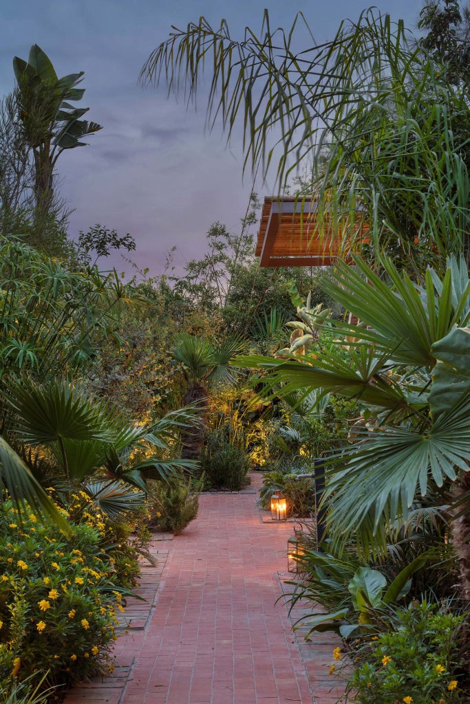 Luxurious Portuguese countryside retreat with stone walls, terracotta roof, lush gardens, and a serene spa surrounded by rolling green hills near scenset.