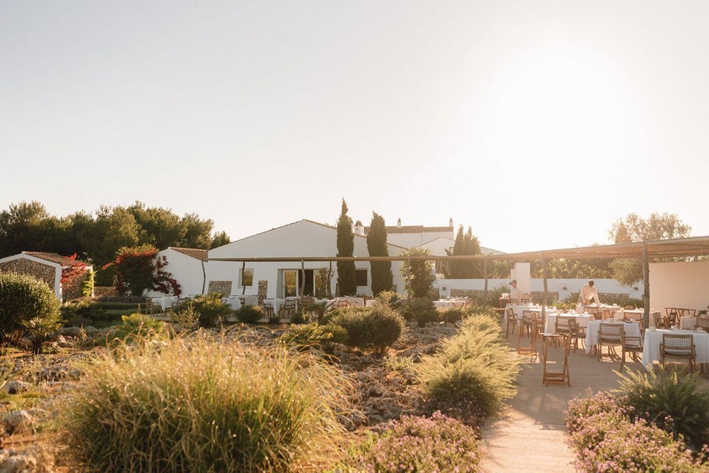 Serene whitewashed Spanish farmhouse hotel nestled in Menorca's countryside, featuring minimalist architecture and traditional Mediterranean stone walls