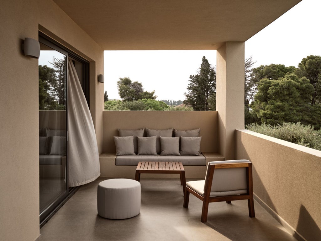 Luxurious white-washed Greek villa bedroom with panoramic Aegean Sea view, elegant minimalist decor, and private terrace overlooking azure waters and scenic coastline