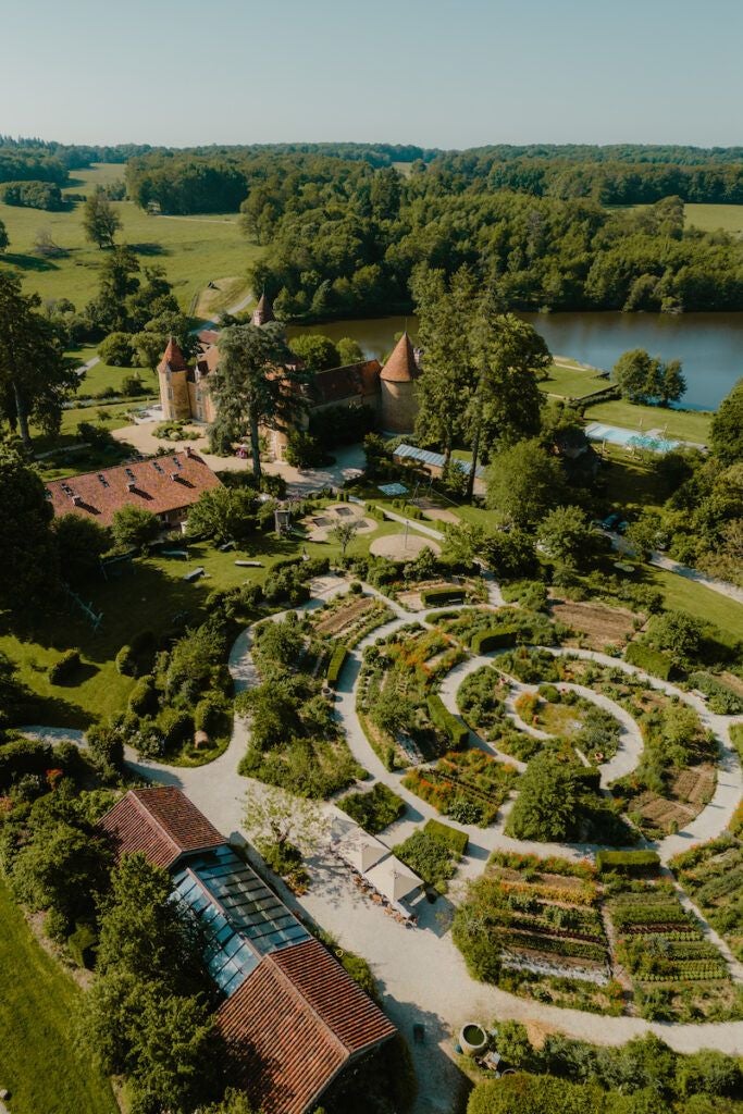 Elegant French château nestled in lush countryside, with stone walls, manicured gardens, and soft natural light creating a serene luxury retreat atmosphere