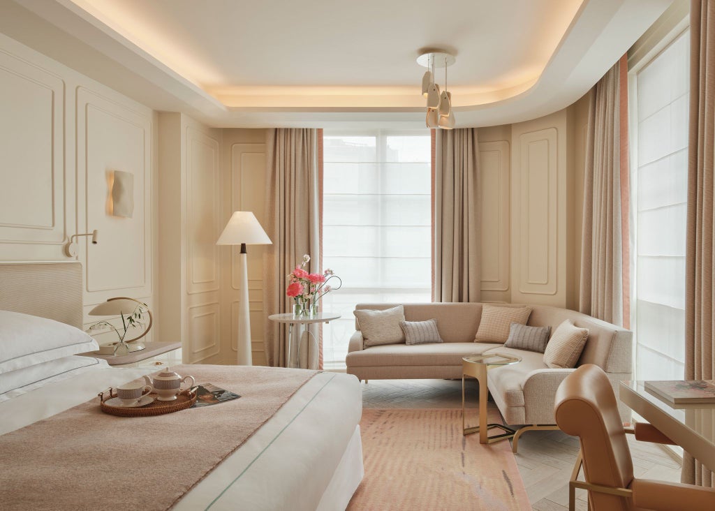 Elegant deluxe hotel room at One Aldwych with modern decor, crisp white linens, plush furnishings, and soft ambient lighting creating a sophisticated urban retreat