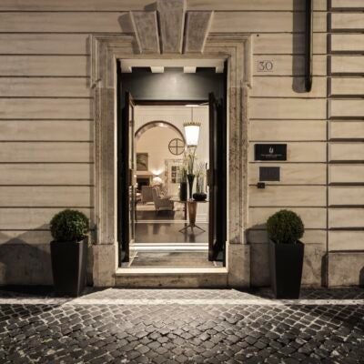 Elegant marble entrance of luxurious boutique hotel with chic Italian design, soft neutral tones, and refined architectural details in Rome's historic center