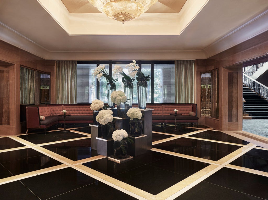 Elegant limestone facade of Four Seasons Boston hotel with classic architecture, manicured gardens and reflective glass windows at sunset