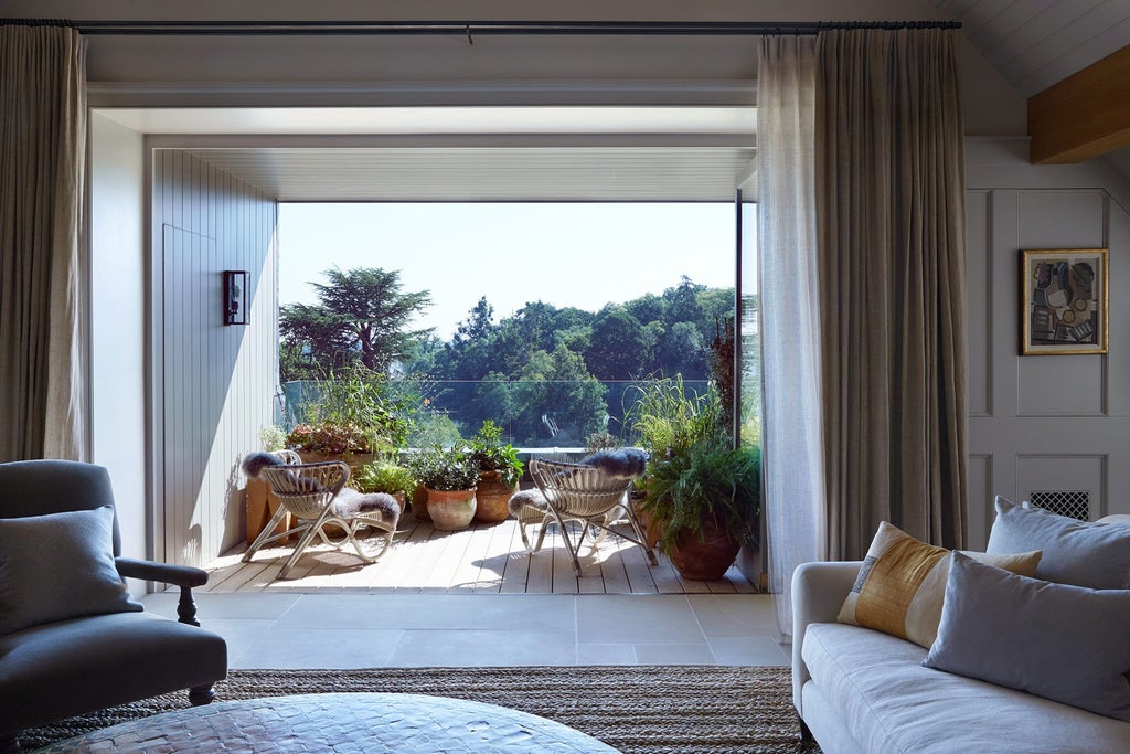 Elegant long hotel room at Heckfield Place with soft neutral tones, expansive windows, classic wooden furniture, and sophisticated minimalist design