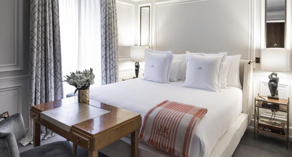 Elegant classic room at scenset Place Paris hotel, featuring luxurious white bedding, soft neutral tones, and sophisticated French-inspired interior design elements