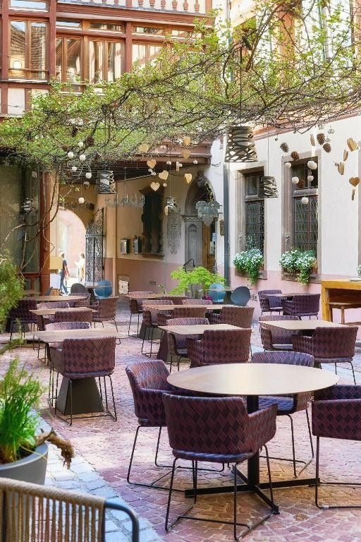 Historic stone facade of Maison des Tetes boutique hotel with ornate Renaissance sculptures, decorative windows and elegant archways in Colmar