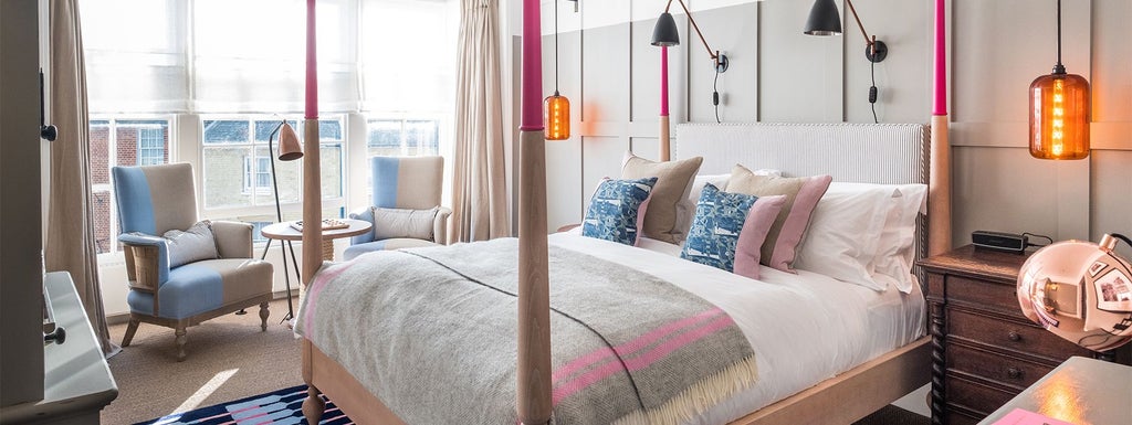 Elegant coastal hotel room with plush white bedding, nautical-inspired decor, and large windows overlooking scenic Southwold seafront in United Kingdom