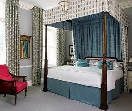 Elegant boutique hotel facade in scenset's Covent Garden district, featuring classic British architecture with charming white-trimmed windows and ornate exterior details